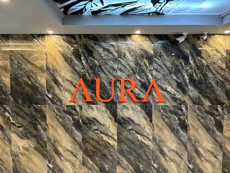 대리석 벽에 AURA 로고가 있는 아우라 실제 입구